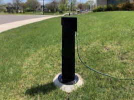 black electrical pedestal on a grassy police department hill